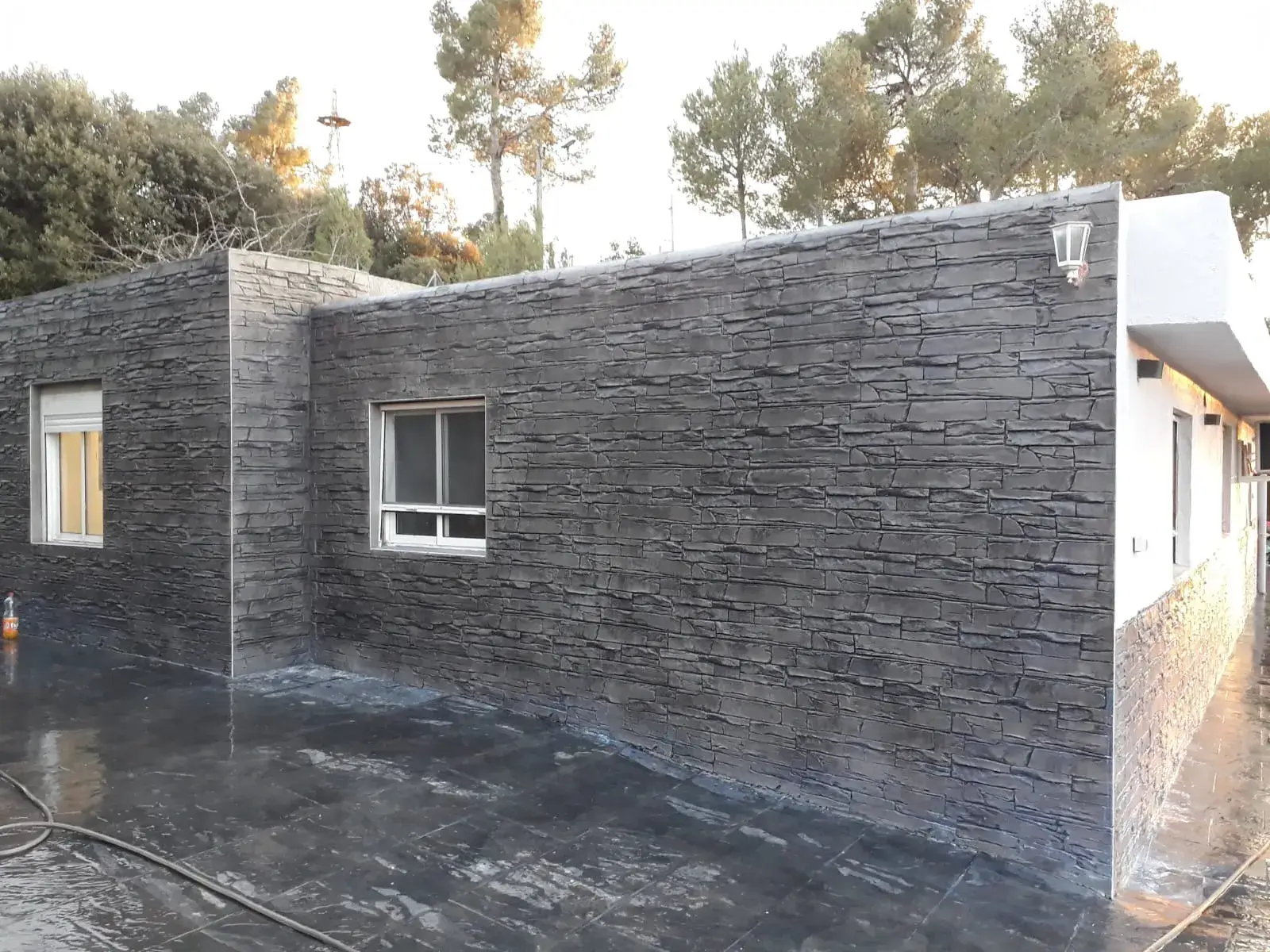 Terasă beton amprentat grafit lângă perete decorativ din piatră