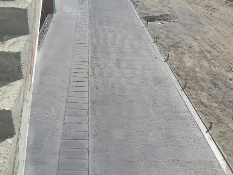 Trotuar din beton periat gri realizat lângă casă cu finisaj modern și margini precise de Rbeton